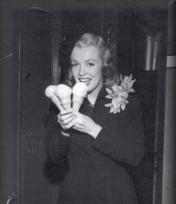 Black and white photograph of Marilyn Monroe holding three ice cream cones.